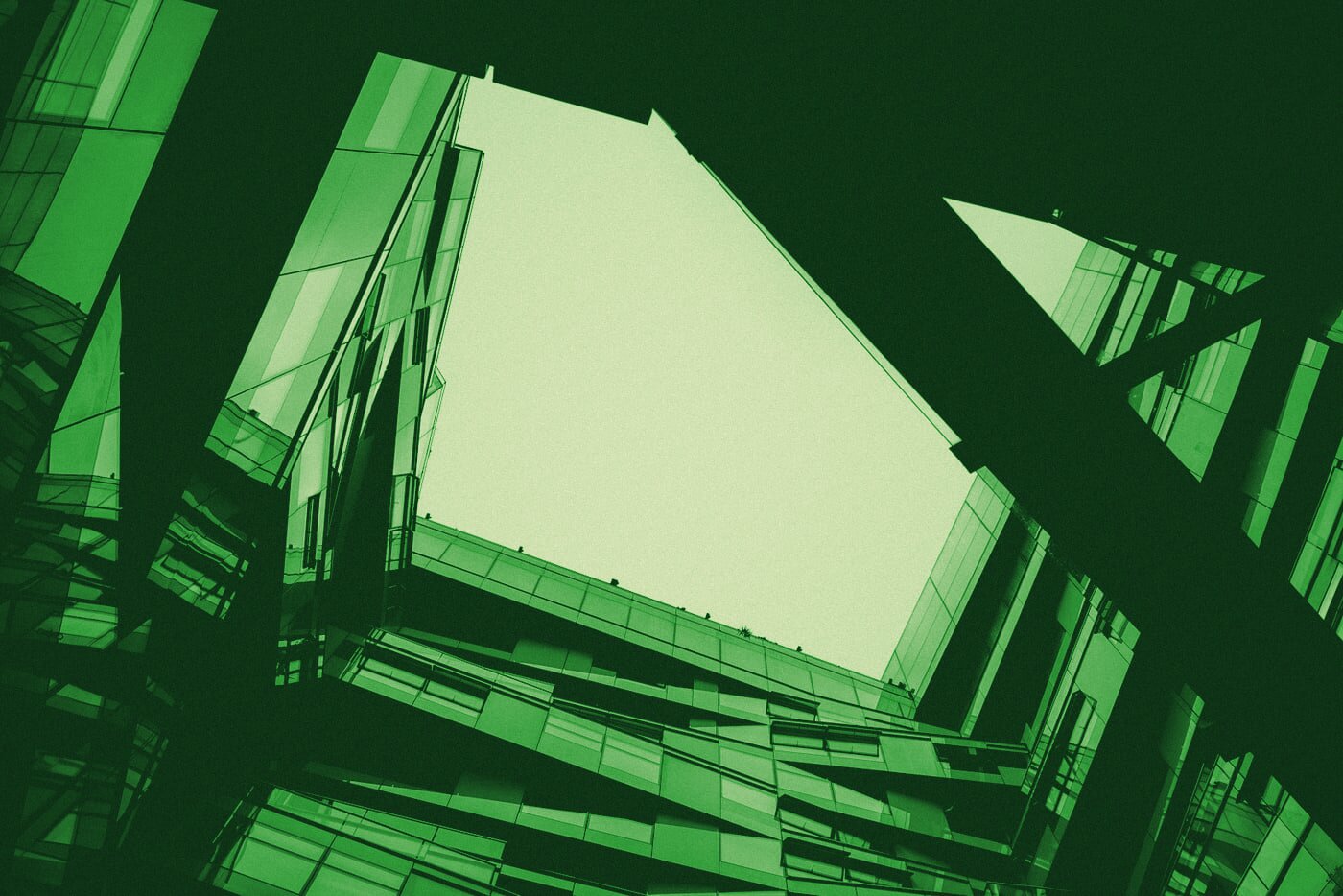 Upward abstract view of a modern institutional building's facade, foreshortened against the sky.